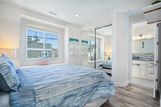 a large bedroom with a bed and wooden floor