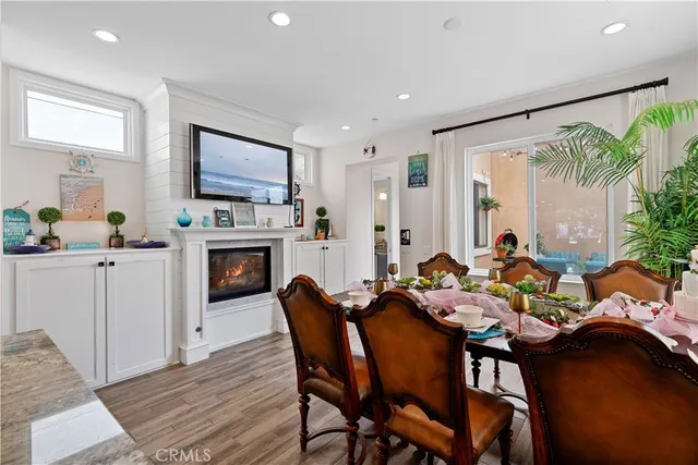 a dining room with furniture a fireplace and wooden floor
