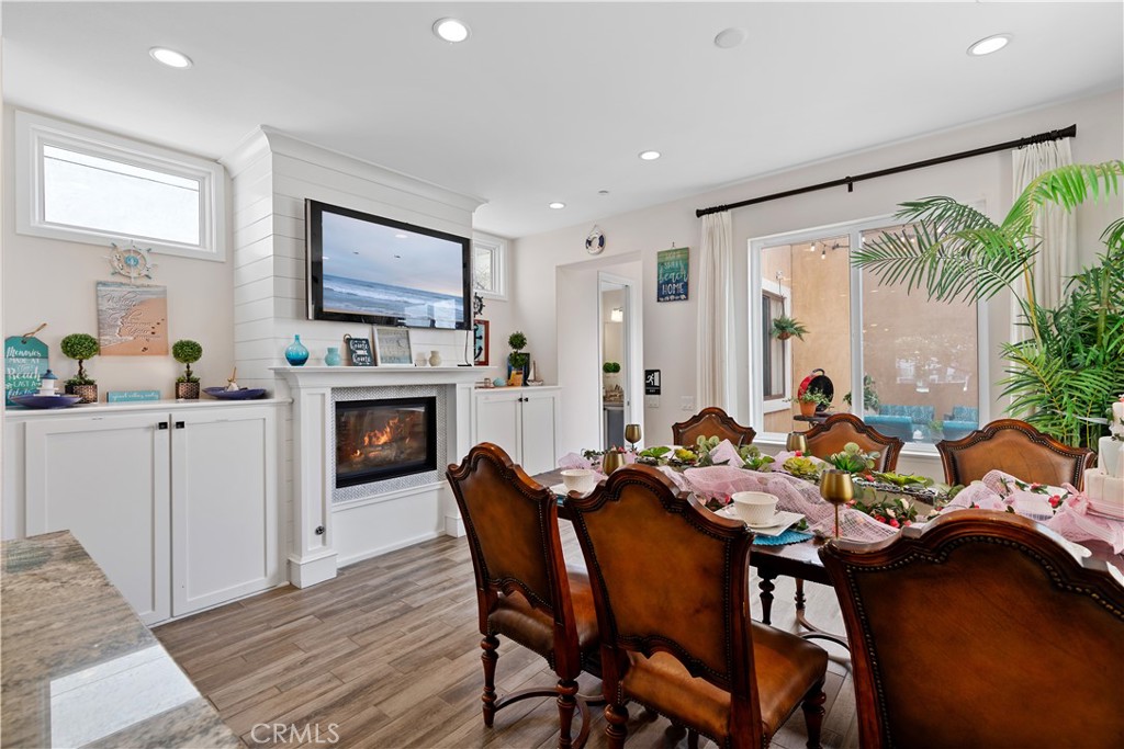 610 17th Street Huntington Beach, CA 92648 - Photo 2 of 64 a dining room with furniture a fireplace and wooden floor