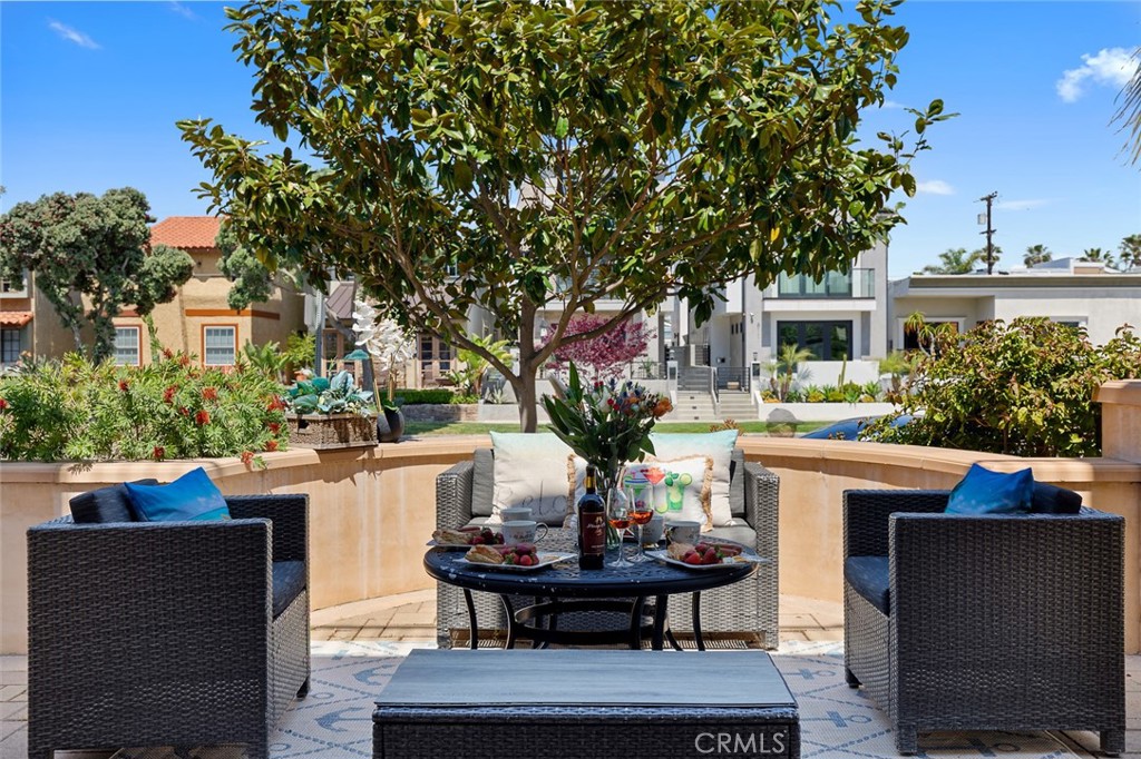 610 17th Street Huntington Beach, CA 92648 - Photo 30 of 64 a view of a patio with table and chairs potted plants and a large tree