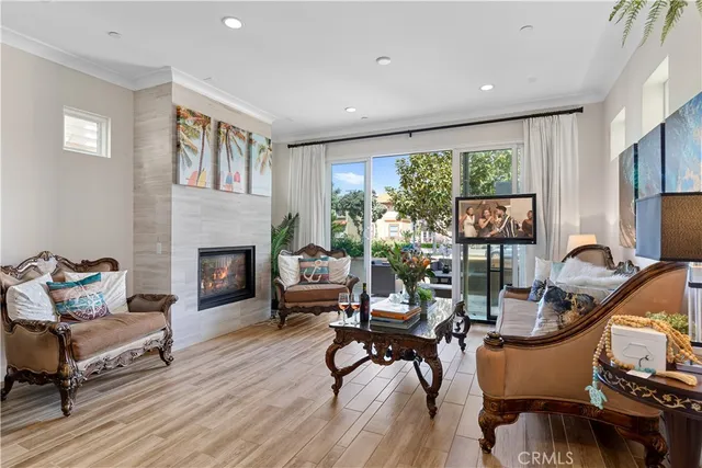 a living room with furniture a fireplace and a floor to ceiling window