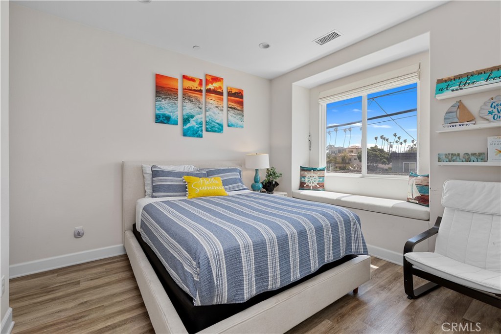 610 17th Street Huntington Beach, CA 92648 - Photo 52 of 64 a bedroom with a bed and wooden floor