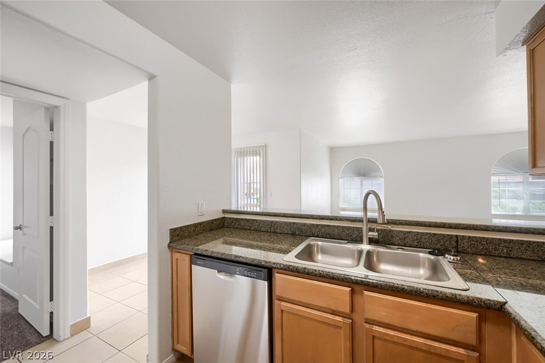 9325 West Desert Inn Road, Unit 177 Las Vegas, NV 89117 - Photo 9 of 24 A well-appointed kitchen features a stainless steel dishwasher and a dual basin sink.