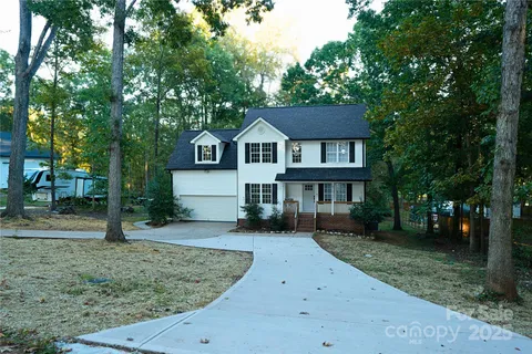 a front view of a house with a yard and trees