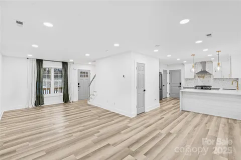 a view of a kitchen with kitchen island wooden floor center island and stainless steel appliances