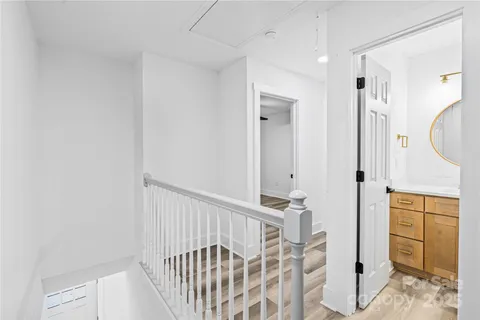 a view of a hallway with wooden floor and staircase