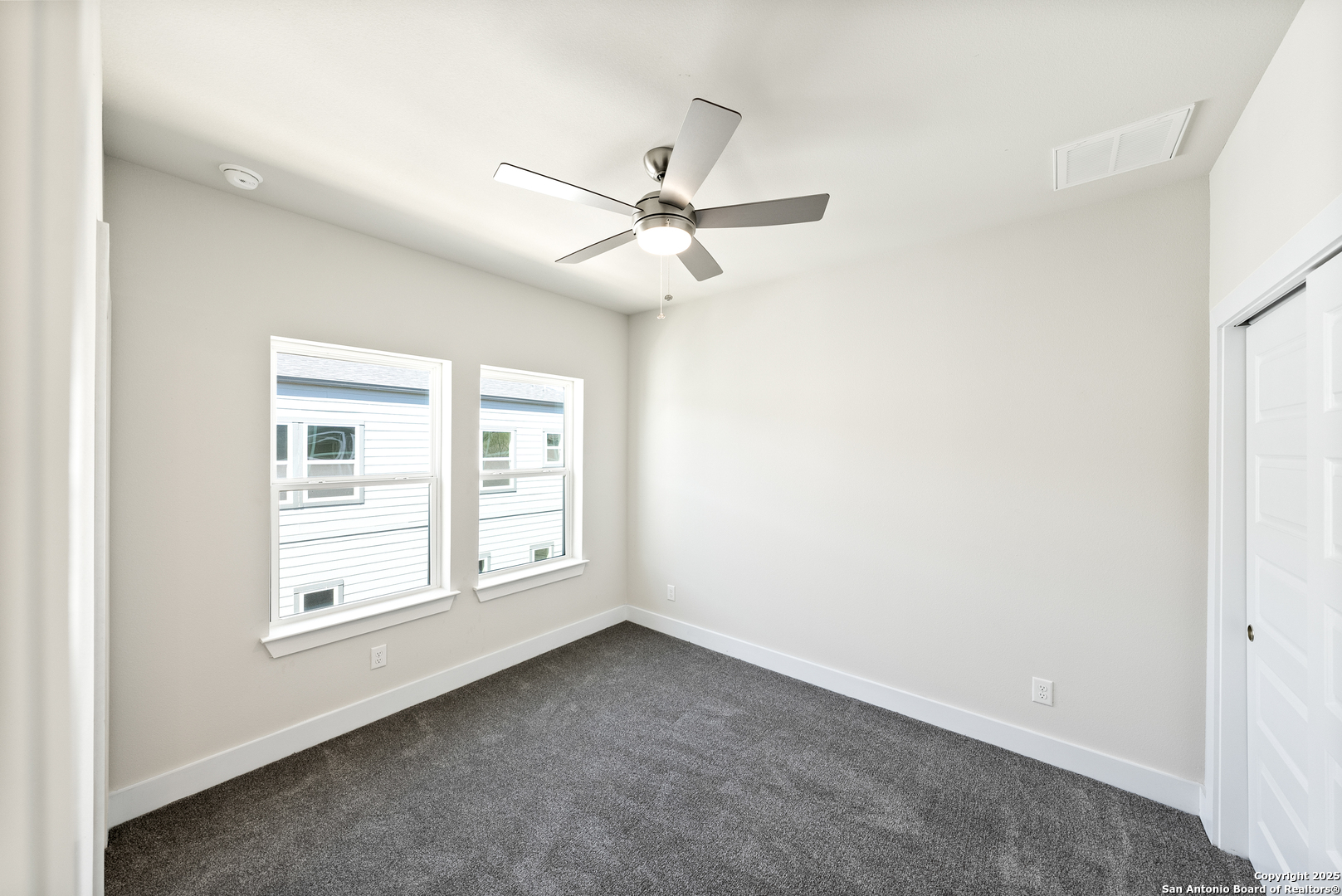 419 Ira Avenue, Unit 1101 San Antonio, TX 78209 - Photo 13 of 22 an empty room with chandelier fan and windows