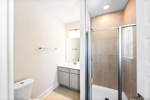 a bathroom with a shower a sink and a toilet
