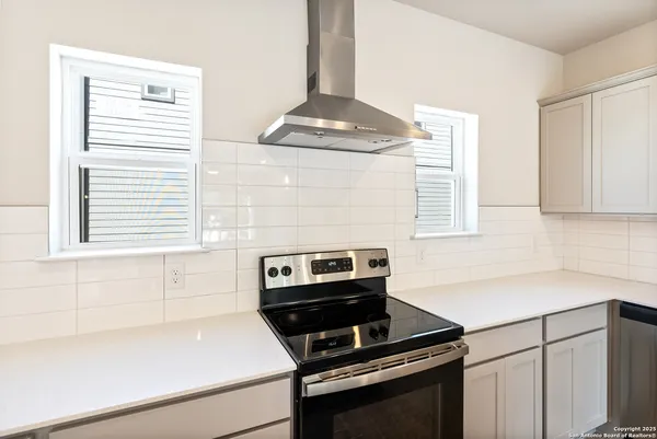 a kitchen with a stove cabinets and a window