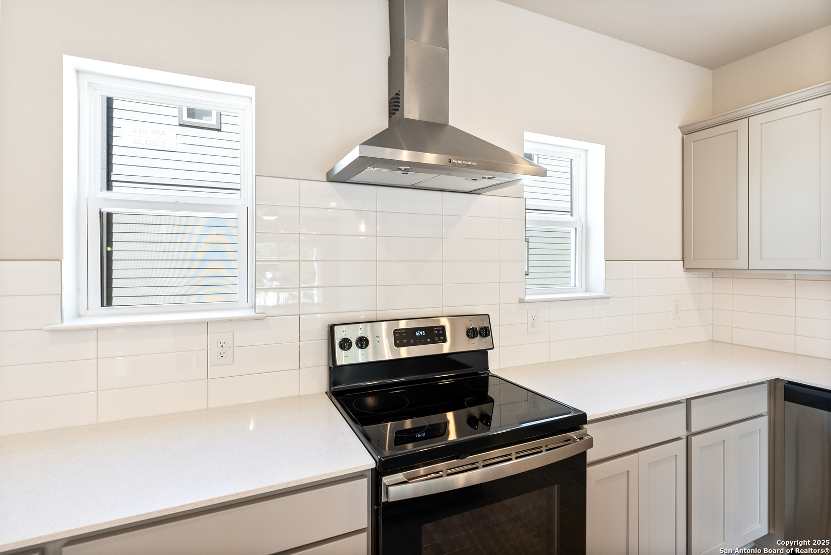 419 Ira Avenue, Unit 1101 San Antonio, TX 78209 - Photo 9 of 22 a kitchen with a stove cabinets and a window