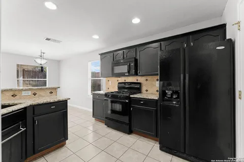 a kitchen with stainless steel appliances granite countertop a refrigerator and a stove top oven