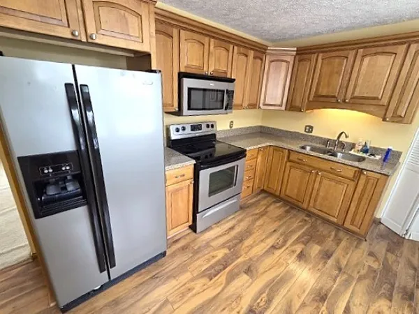 a kitchen with stainless steel appliances granite countertop a refrigerator stove and sink