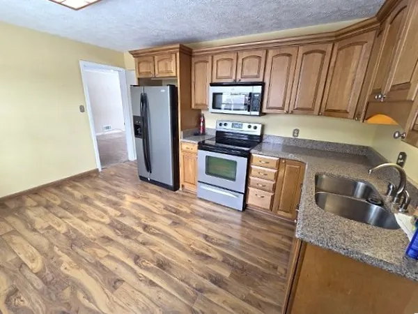 a kitchen with stainless steel appliances granite countertop a refrigerator sink and stove
