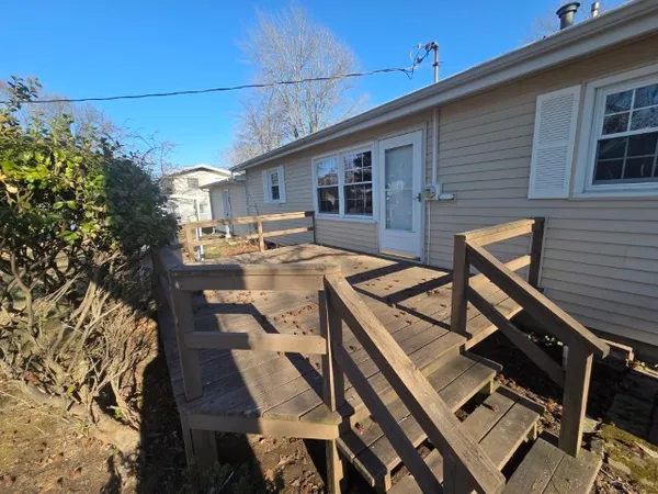 a view of a patio with table and chairs with wooden floor and fence