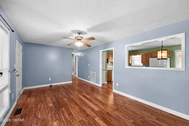 a view of a livingroom with a ceiling fan and window
