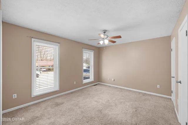 an empty room with closet and a chandelier fan