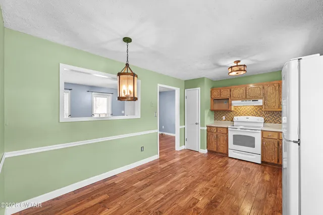 a kitchen with a refrigerator and a stove top oven