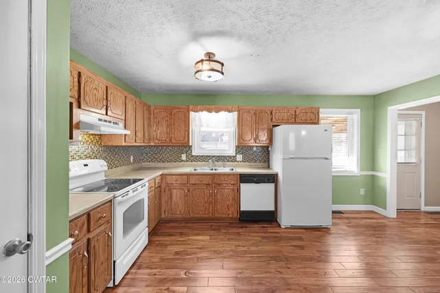 a view of empty room with wooden floor and window
