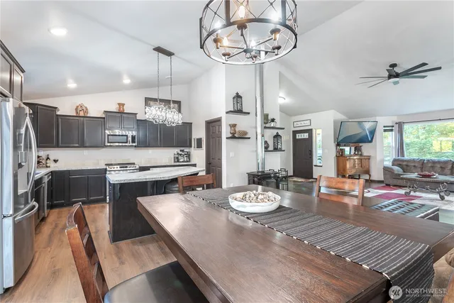 a open dining room with stainless steel appliances furniture a chandelier and kitchen view