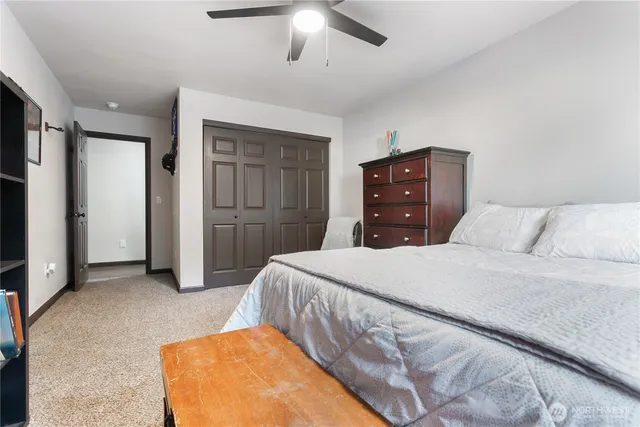 a bedroom with a bed and a ceiling fan