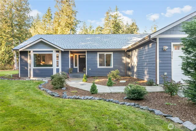 a front view of a house with a yard and outdoor seating