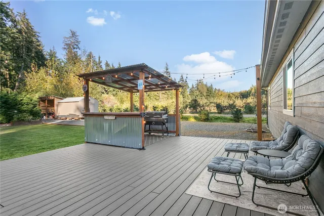 a view of a patio with table and chairs under an umbrella with wooden floor and fence