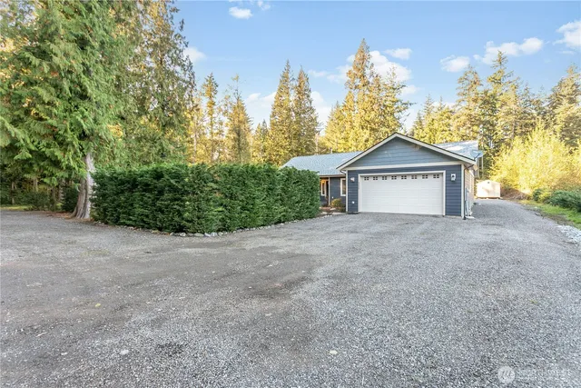 a view of a house with a yard and large trees