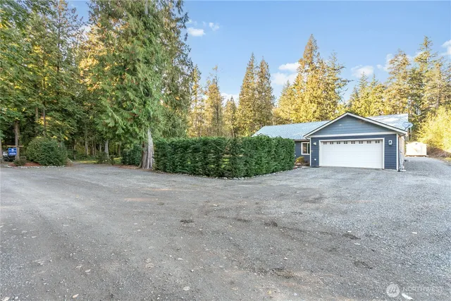 a view of a house with a yard and large trees