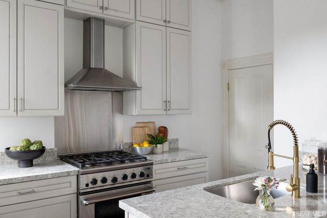 a kitchen with granite countertop a stove and a wooden cabinets