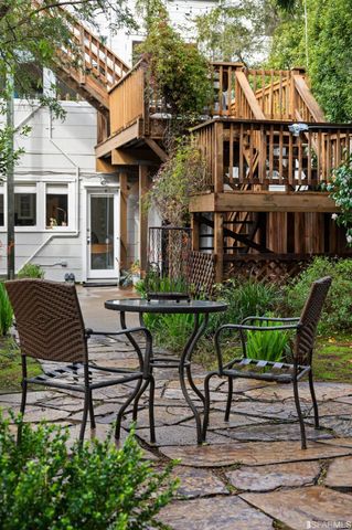 a patio table and chairs with potted plants and large trees