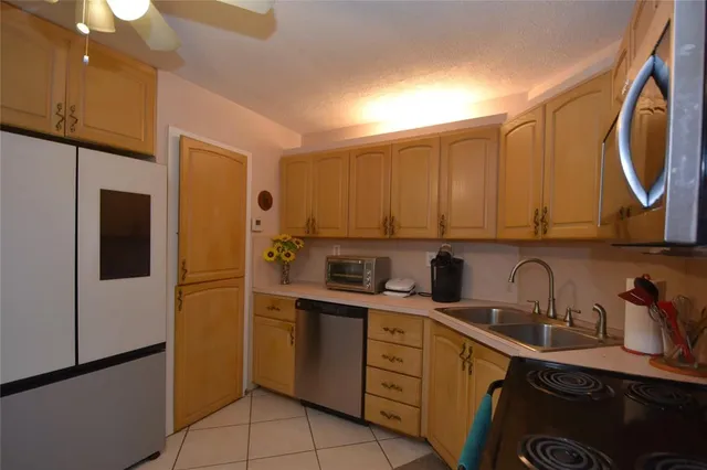 a kitchen with a sink a refrigerator and cabinets