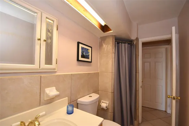 a bathroom with a toilet a sink and a mirror