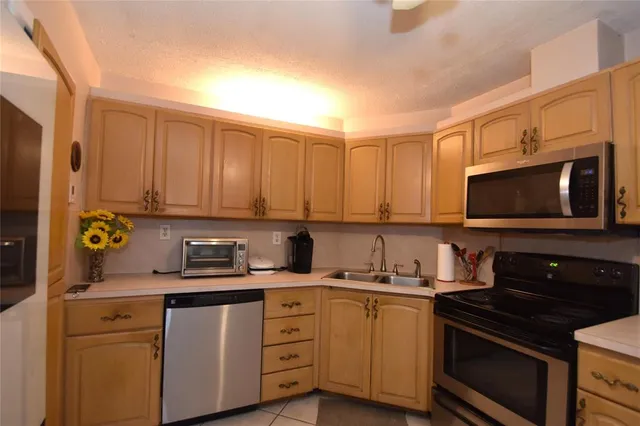 a kitchen with stainless steel appliances a stove a sink and a microwave