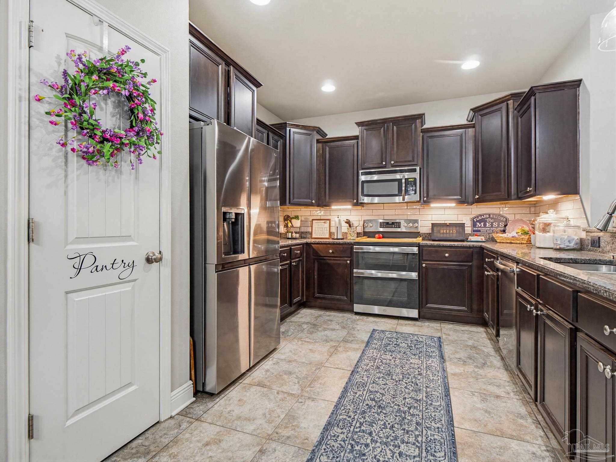 6294 Ladera Trail Pace, FL 32571 - Photo 11 of 50 a kitchen with stainless steel appliances granite countertop a refrigerator and a sink