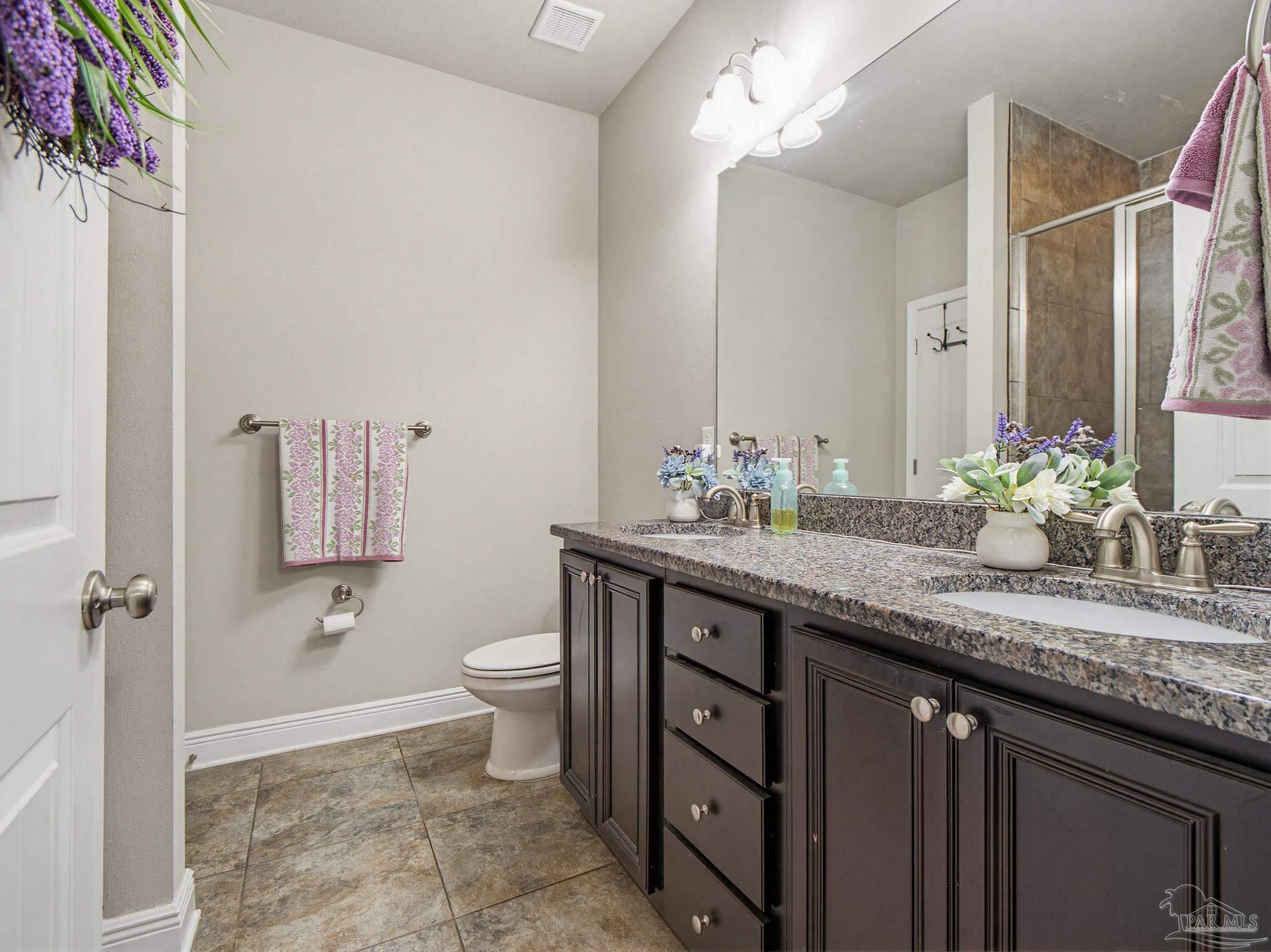 6294 Ladera Trail Pace, FL 32571 - Photo 19 of 50 a bathroom with a granite countertop sink a toilet and a mirror