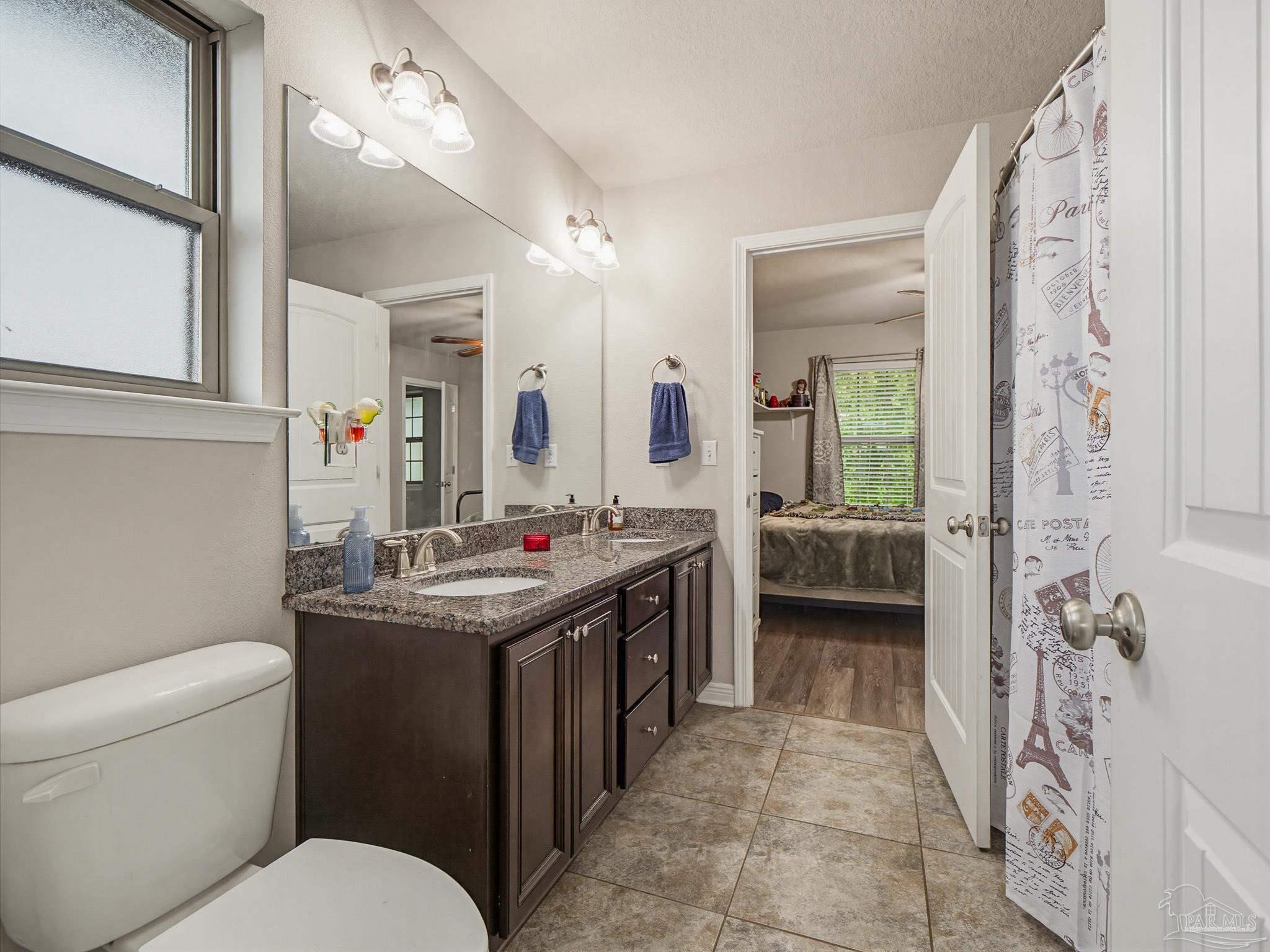 6294 Ladera Trail Pace, FL 32571 - Photo 36 of 50 a bathroom with a toilet sink and mirror