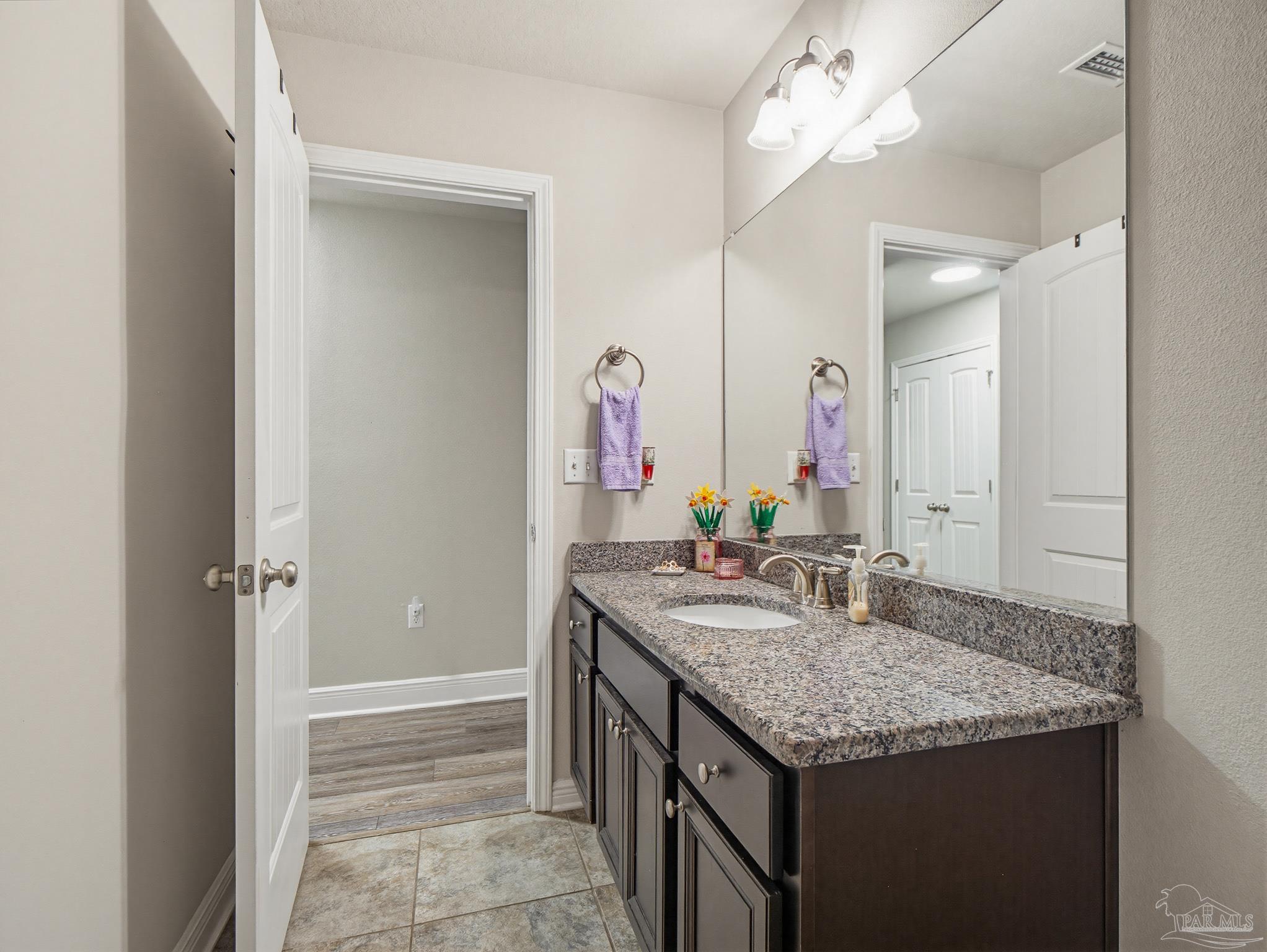 6294 Ladera Trail Pace, FL 32571 - Photo 44 of 50 a bathroom with a granite countertop sink a large mirror and a shower