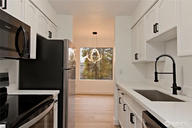 a kitchen with stainless steel appliances a stove microwave and refrigerator