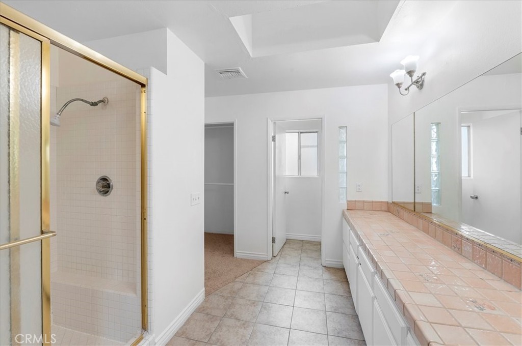 1128 South Parton Street Santa Ana, CA 92707 - Photo 13 of 32 a spacious bathroom with a granite countertop sink a mirror a shower and a bathtub