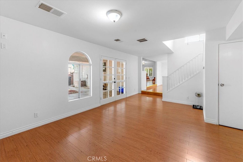 1128 South Parton Street Santa Ana, CA 92707 - Photo 5 of 32 an empty room with wooden floor and windows