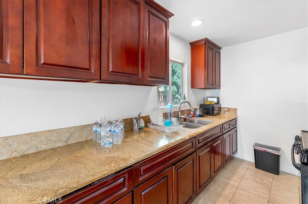 1128 South Parton Street Santa Ana, CA 92707 - Photo 8 of 32 a kitchen with stainless steel appliances granite countertop a sink dishwasher stove and cabinets