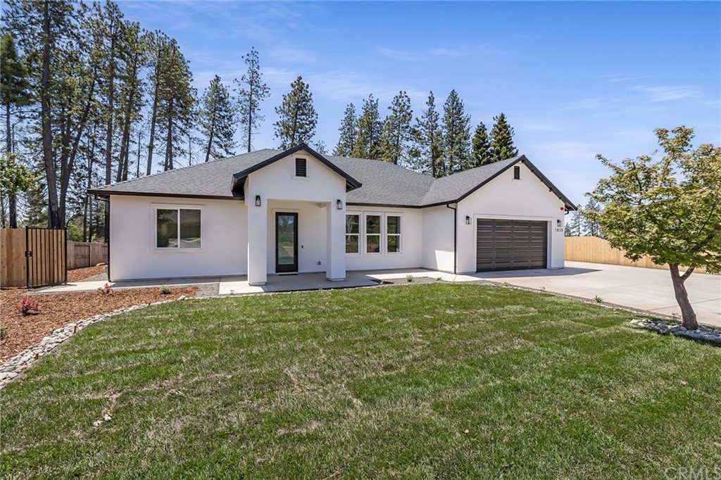 a view of a yard in front of a house with large tree