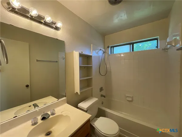 a view of an house with backyard and a tree