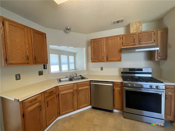 a kitchen with a stove sink and cabinets