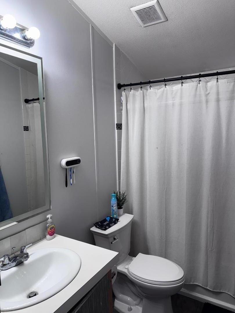 4320 Monterey Road, Unit 16 San Jose, CA 95111 - Photo 8 of 13 a bathroom with a sink a toilet a mirror and shower curtain