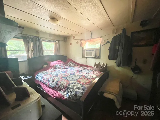 a bedroom with a bed and a lamp on dresser