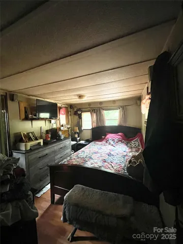 a bedroom with a bed closet and flat screen tv