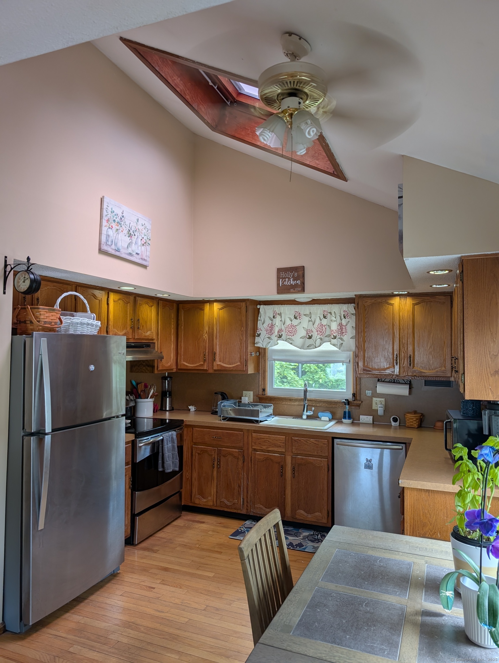 2805 Boston Post Road Guilford, CT 06437 - Photo 17 of 35 a kitchen with stainless steel appliances granite countertop a refrigerator a sink a stove a dining table and chairs with wooden floor