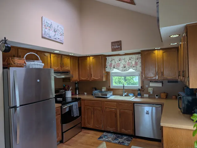 a kitchen with stainless steel appliances a refrigerator a sink a stove and a refrigerator