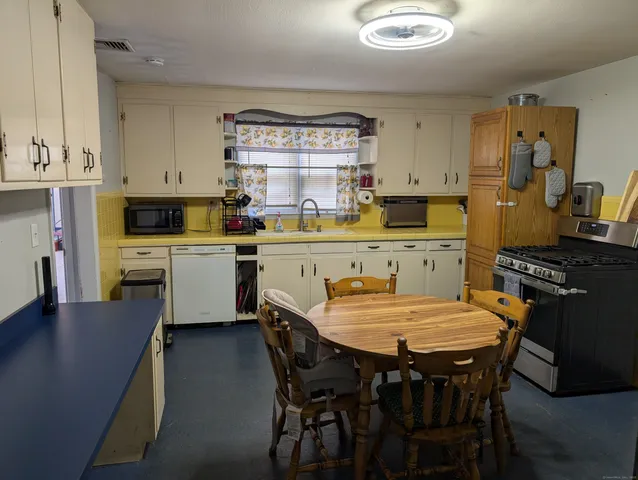 a dining room with a table chairs and a kitchen view